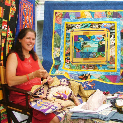 Lakes Region Fine Arts and Crafts Festival, woman demonstrating quilt making.