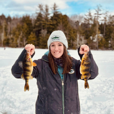 Ice fishing derby Meredith, NH, woman holding fish she caught.